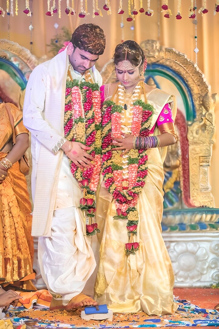 Telugu bride and groom in garlands during the wedding ritual on the mandapam